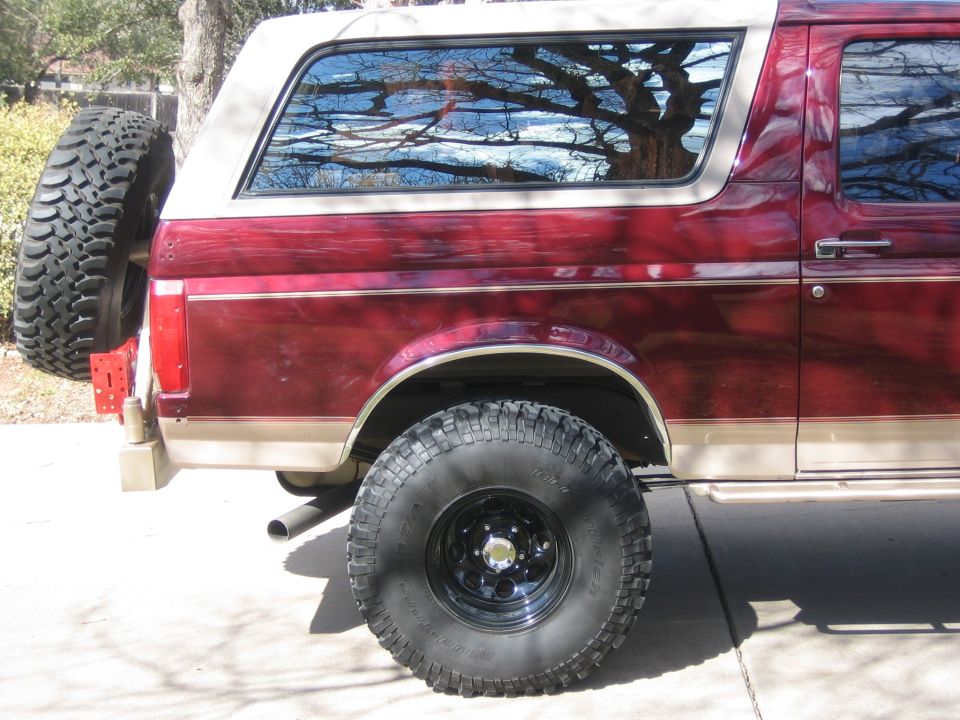 Red and tan 1996 Ford Bronco rear quarter panel with spare tire