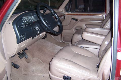 1996 Ford Bronco - The interior of the vehicle features tan leather seats and a dashboard with visible gauges.