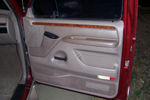 1996 Ford Bronco - Interior view of a tan door panel wood trim and power window controls, consistent with a 1996 Ford Bronco.