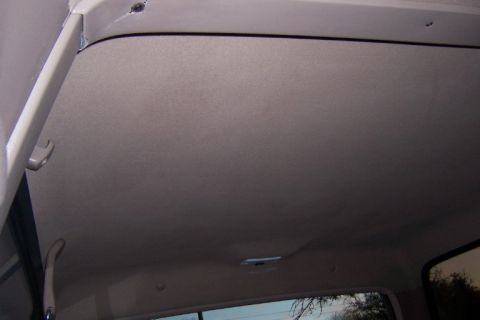 1996 Ford Bronco - Close-up view of a vehicle's interior ceiling, showing grab handles and a light.