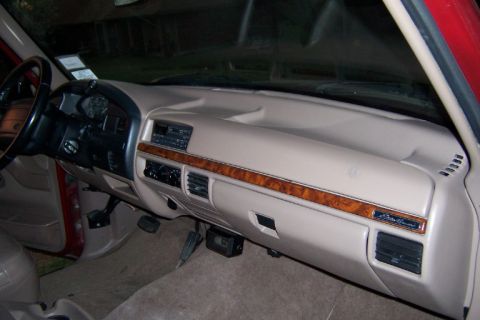 1996 Ford Bronco - The tan interior dashboard features wood trim accents and air vents.