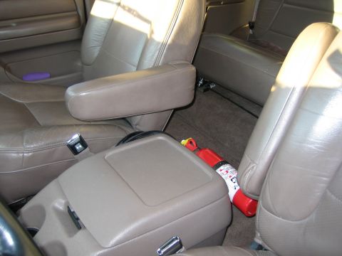 1996 Ford Bronco - Interior view of a vehicle, tan leather seats and a fire extinguisher stored between the seats.