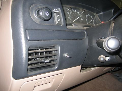 1996 Ford Bronco - The dashboard of a vehicle shows an air vent, light controls, and a toggle switch.
