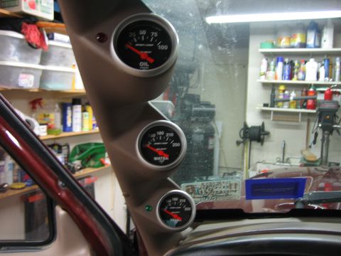 1996 Ford Bronco - Interior shot of a vehicle's A-pillar with three gauges installed, showing oil pressure, water temperature, and voltage readings.