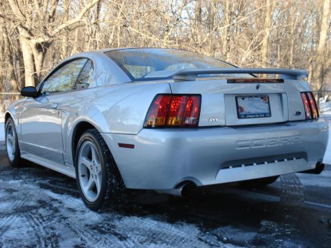 1998 Ford Taurus - A silver 1999 Ford Mustang SVT Cobra is parked on a snowy road, viewed from the rear three-quarter angle.
