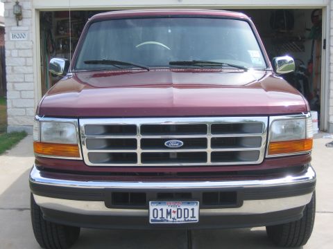 1996 Ford Bronco - Front view of a maroon 1996 Ford Bronco parked in front of a garage.