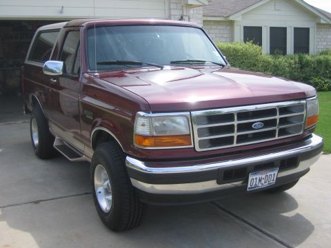 1996 Ford Bronco - Maroon 1996 Ford Bronco parked in front of a garage and house.