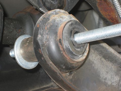 1996 Ford Bronco - A threaded bolt is being installed through a rubber bushing as part of a suspension lift.