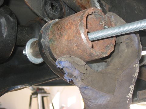 1996 Ford Bronco - A close-up view of a rusted metal tube and a threaded rod, likely part of a vehicle's suspension system.