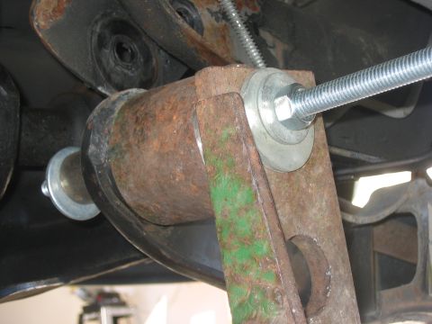 1996 Ford Bronco - This image shows a rusty metal component of a vehicle's suspension system, likely during a lift installation.