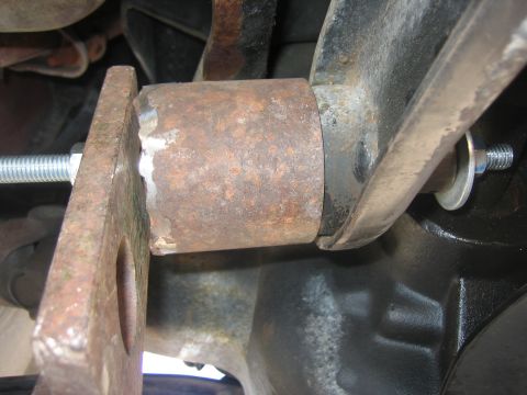 1996 Ford Bronco - Close-up of a rusty lift kit component, showing a bolt and washer securing it to a vehicle's suspension.