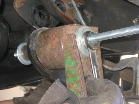 1996 Ford Bronco - Close-up of a wrench working on a vehicle's suspension system.
