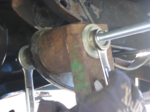 1996 Ford Bronco - Close-up of a vehicle's undercarriage, focusing on a suspension component during maintenance.