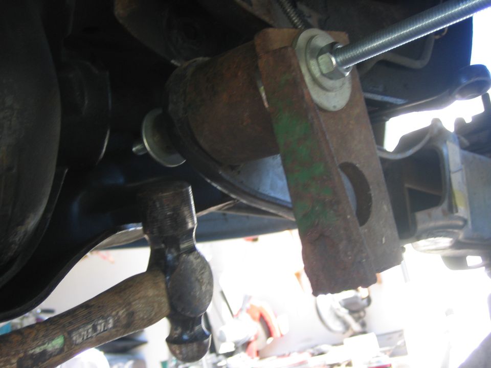 Close-up of rusty suspension part with hammer