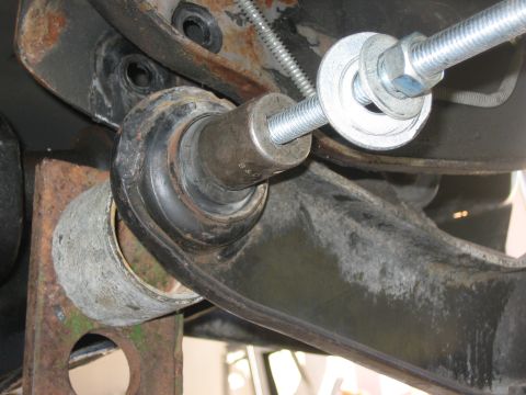 1996 Ford Bronco - A close-up view of a vehicle's suspension component undergoing installation or adjustment.