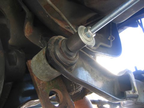 1996 Ford Bronco - Installation of a suspension part, showing a threaded rod and hardware.