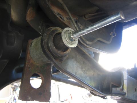 1996 Ford Bronco - Close-up view of a suspension component with a threaded rod being installed, likely for a lift kit.