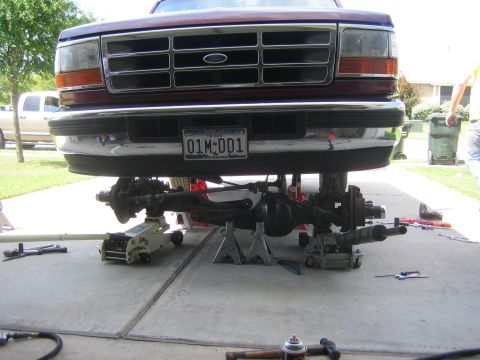 1996 Ford Bronco - Front axle and suspension components of a 1996 Ford Bronco are visible while the vehicle is lifted for maintenance.