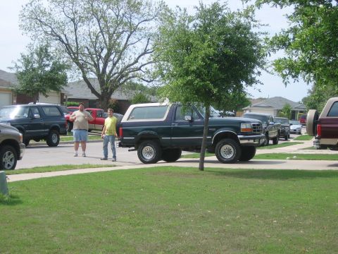 1996 Ford Bronco - A 1996 Ford Bronco is parked on a suburban street alongside other vehicles.