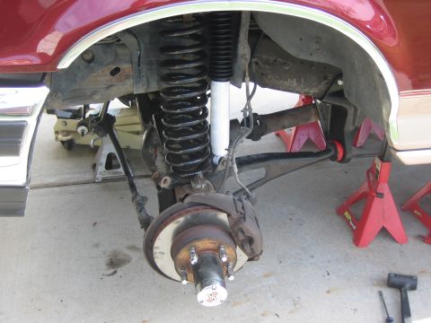 1996 Ford Bronco - Front suspension of a 1996 Ford Bronco, showing lifted coil springs and new shocks during a lift install.