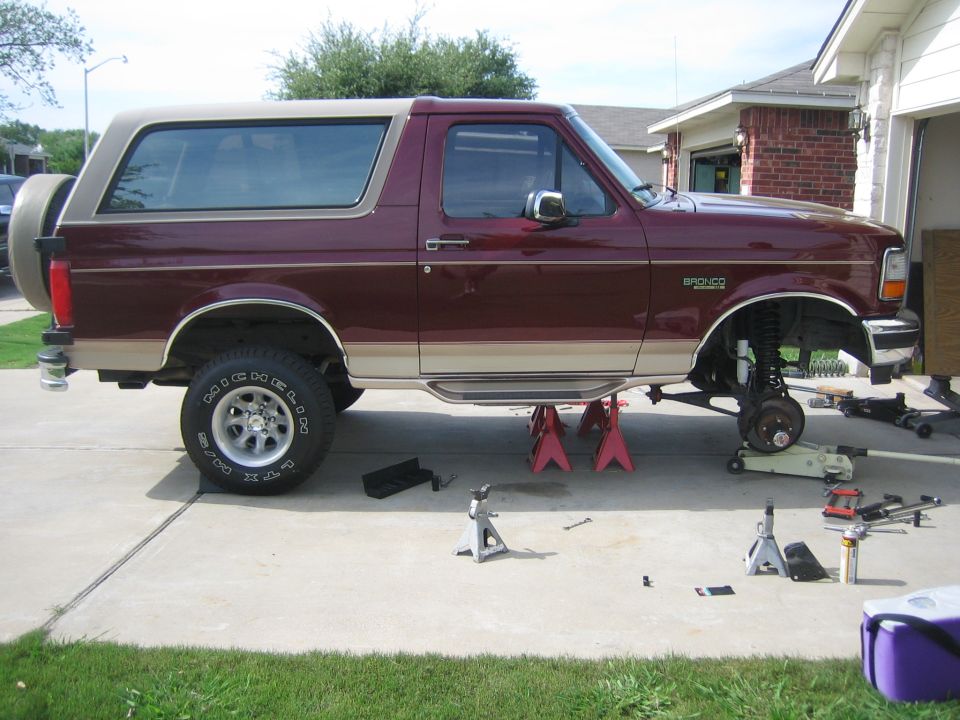 1996 Ford Bronco lifted on jack stands with front wheel removed for maintenance