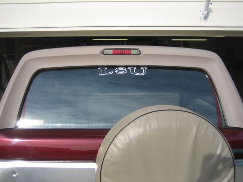 1996 Ford Bronco - The rear of a maroon and silver SUV is shown, a spare tire cover and an LSU decal on the window.