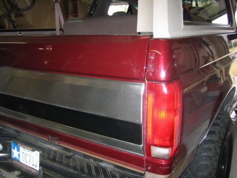 1996 Ford Bronco - Rear view of a red Ford Bronco showing its distinctive body style and trim details.