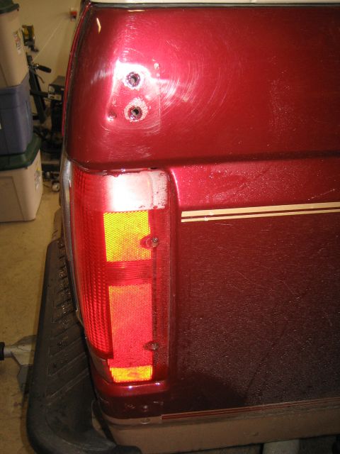1996 Ford Bronco - Close-up of the rear quarter panel and taillight assembly on a red 1996 Ford Bronco.
