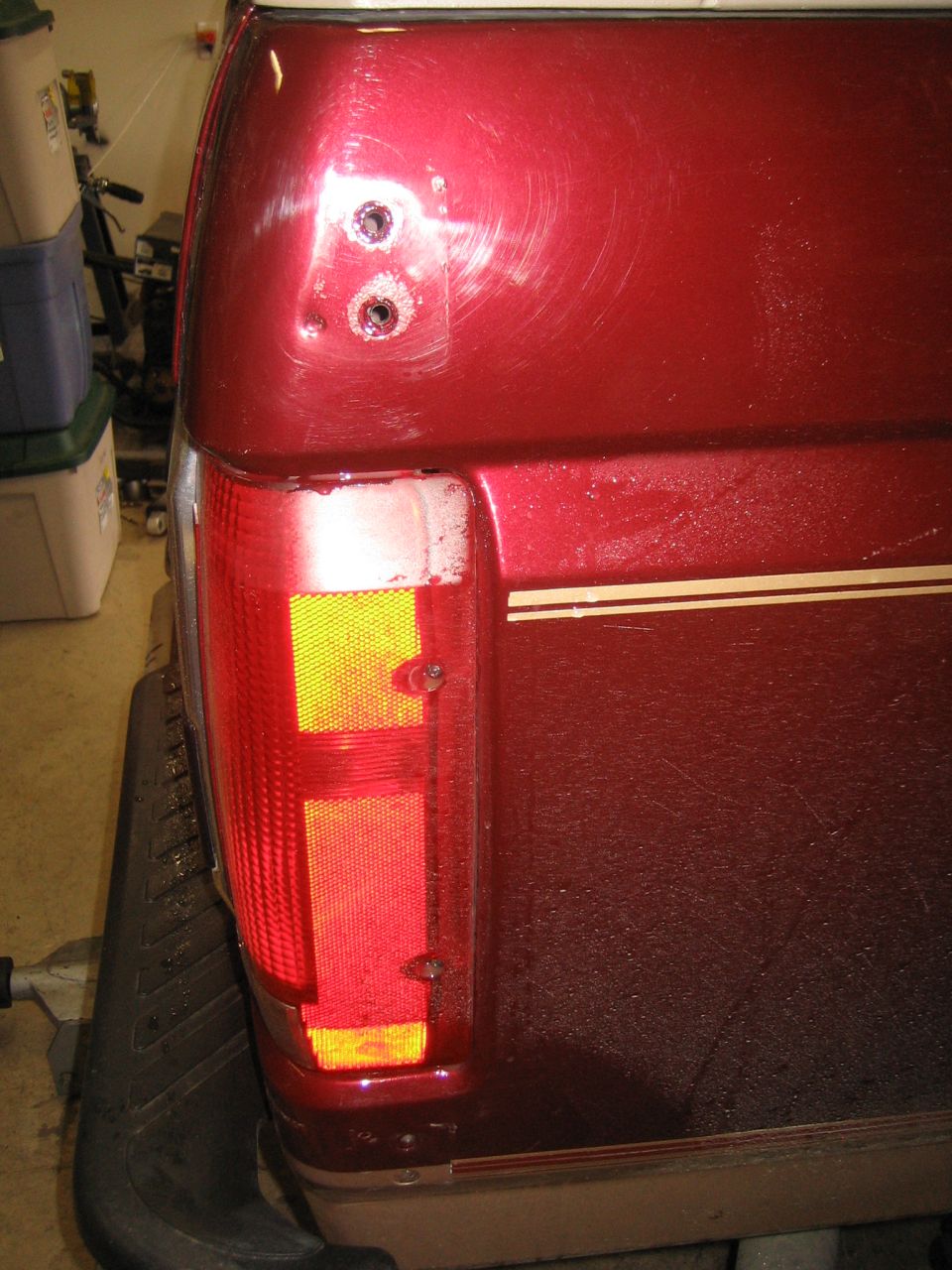 Red 1996 Ford Bronco rear quarter panel with taillight and gold stripe