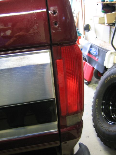 1996 Ford Bronco - The rear section of a vehicle is shown, with a focus on the taillight and trim details.