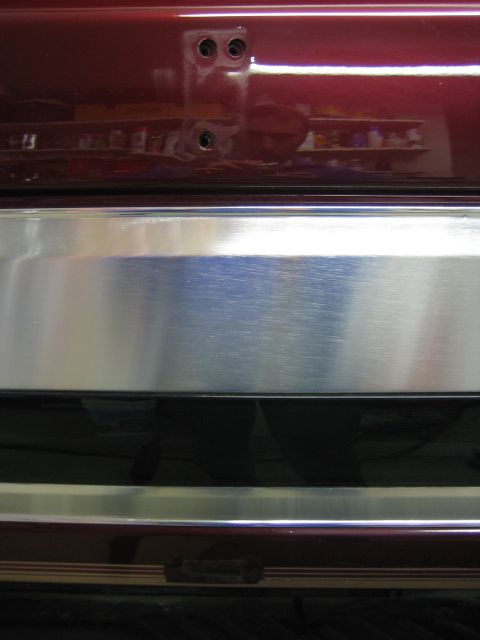 1996 Ford Bronco - Close-up of the rear bumper on a red 1996 Ford Bronco, showing chrome accents and mounting points.