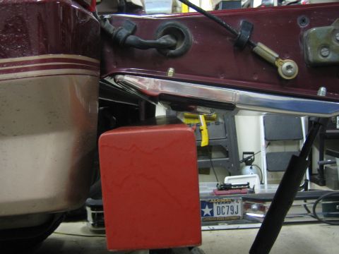 1996 Ford Bronco - Close-up of a vehicle's rear bumper assembly, showing a red block and maroon panel.