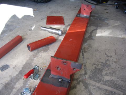 1996 Ford Bronco - Red metal bumper components and tools are laid out on a concrete surface, suggesting a build or repair project.