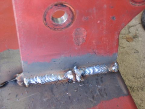 1996 Ford Bronco - This is a close-up view of a red metal bracket that has been welded.