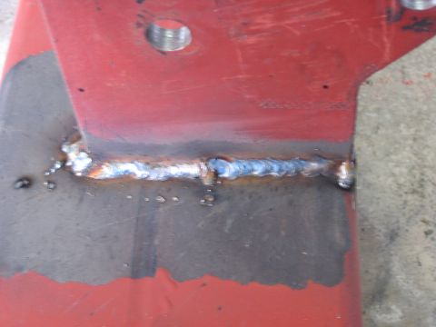 1996 Ford Bronco - Close-up of a welded metal bracket, showing a seam and a hole.