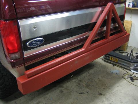 1996 Ford Bronco - The rear of a Ford Bronco shows a custom red bumper with a spare tire carrier attachment.