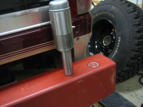 1996 Ford Bronco - A close-up of a vehicle's rear bumper and tire, with an aftermarket addition mounted on the bumper.