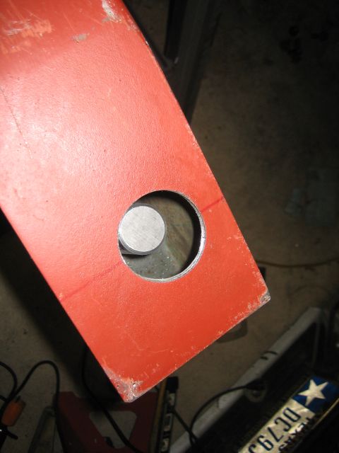 1996 Ford Bronco - Close-up of a red metal bracket with a hole, possibly for a build or repair.