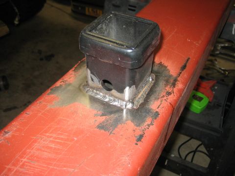 1996 Ford Bronco - A close-up shows a newly welded trailer hitch receiver attached to a red metal bar.