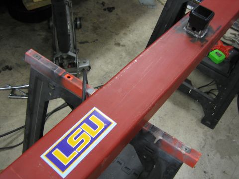 1996 Ford Bronco - A red metal bar, possibly a trailer hitch receiver, is shown with an LSU sticker and appears to be undergoing some modification or repair.