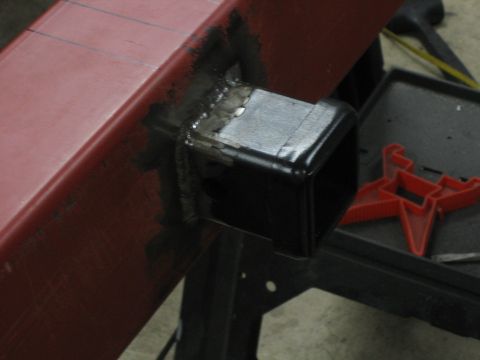 1996 Ford Bronco - A trailer hitch receiver is welded onto a red metal frame, showing the construction detail.