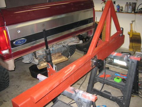 1996 Ford Bronco - A custom red metal fabrication is positioned in front of the rear of a Ford truck, possibly for installation.