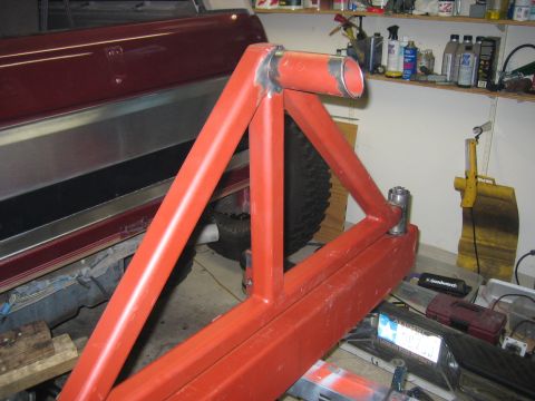 1996 Ford Bronco - Custom rear bumper and tire carrier assembly, partially attached to a vehicle in a garage setting.