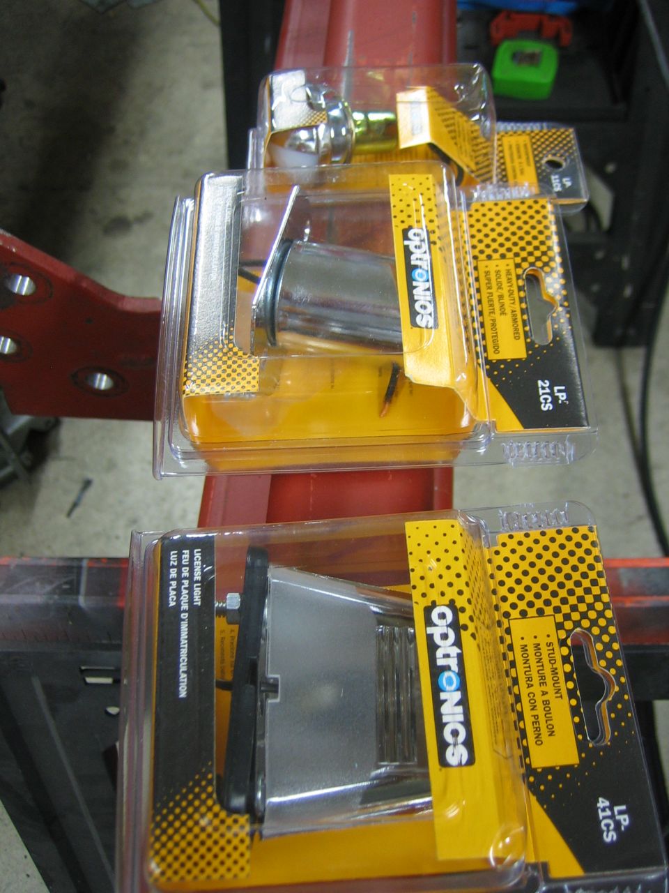 Two Optronics license plate lights in yellow and black packaging
