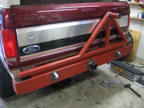 1996 Ford Bronco - Rear view of a 1996 Ford Bronco showing a custom-built red metal tire carrier mounted over the bumper.