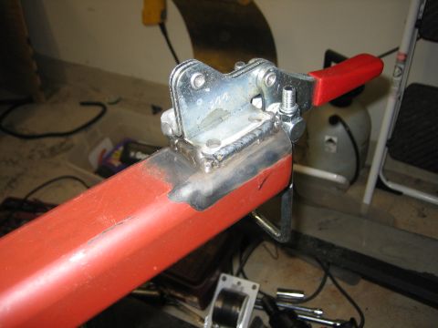 1996 Ford Bronco - A metal bracket is welded onto a red tube, likely part of a custom build.