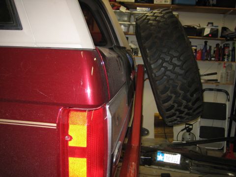 1996 Ford Bronco - Rear view of a red SUV showing its taillight and a spare tire mounted on the back.