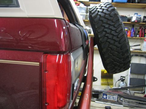 1996 Ford Bronco - The rear of a 1996 Ford Bronco shows its taillight and a spare tire mounted on a custom rack.