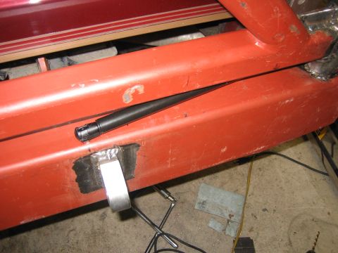 1996 Ford Bronco - Detail of a red metal frame, possibly part of a custom bumper build, with a black rod and welding.