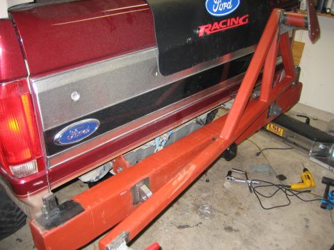 1996 Ford Bronco - Custom orange spare tire carrier mounted to the rear of a red Ford Bronco, with Ford Racing decals on the tailgate.